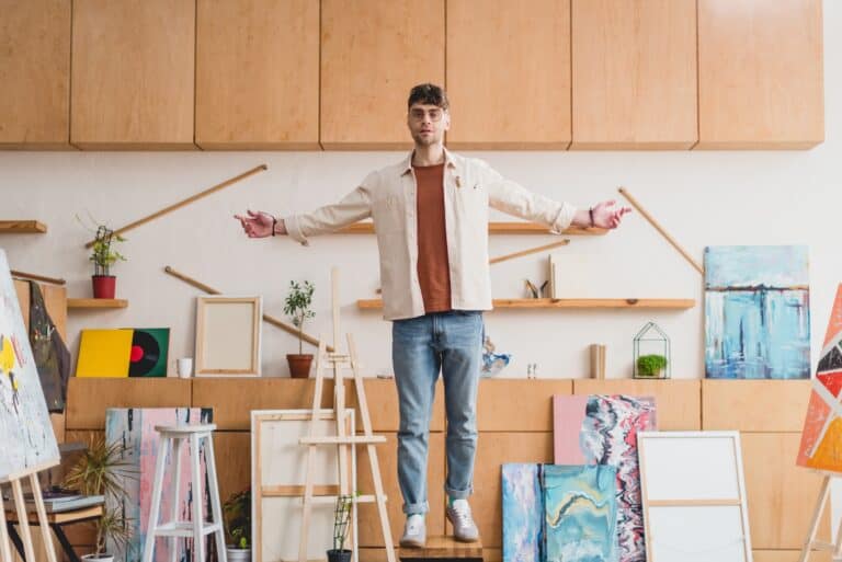 man-standing-on-chair-in-art-room