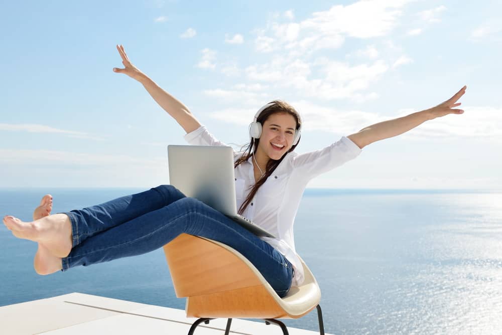 happy-woman-working-on-laptop-outdoors