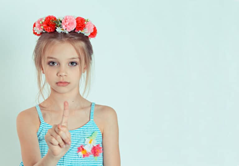 kid gesturing a no sign. portrait unhappy, serious child girl raising finger up saying oh no, you do not have to do that isolated white green background. Negative emotions, facial expressions feelings