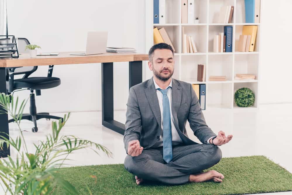 business-man-meditating-on-grass-matt