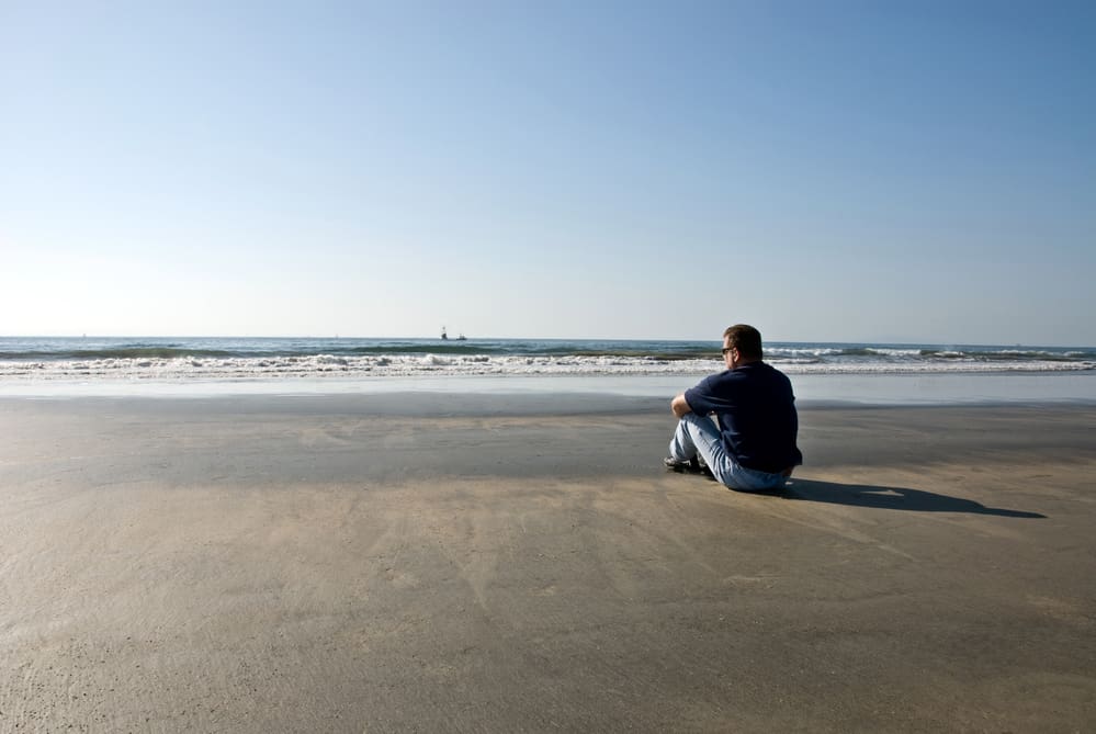 man-sitting-alone-at-a-beach