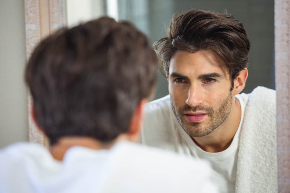 man-looking-at-reflection-of-himself-in-mirror