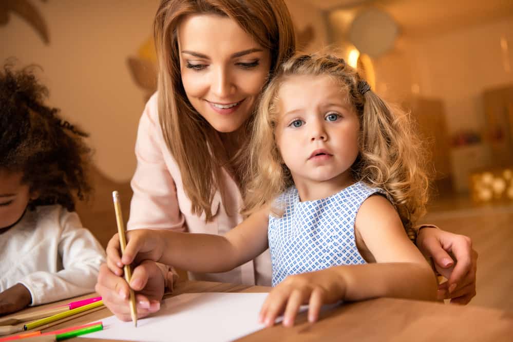 teacher-helping-kid-draw