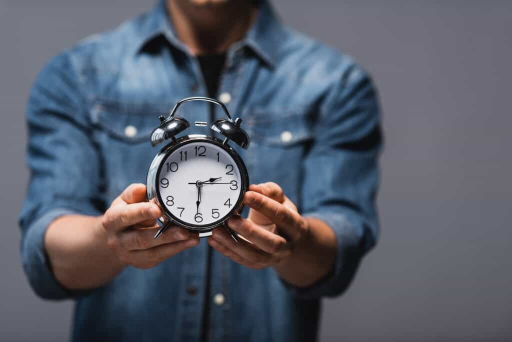 man-holding-alarm-clock