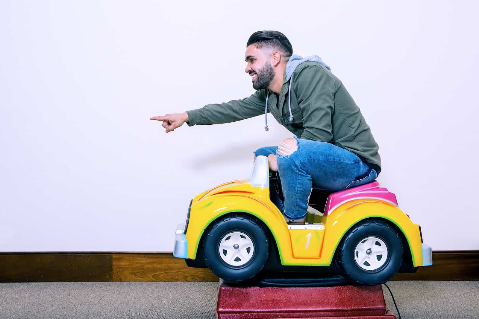 cheerful-man-riding-kids-car