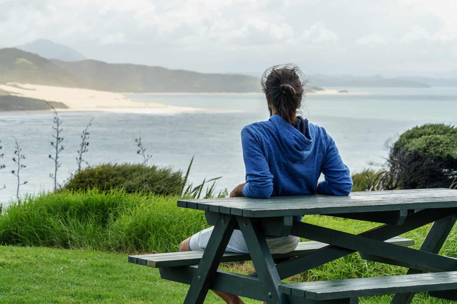 man-sitting-alone-overlooking-ocean-view