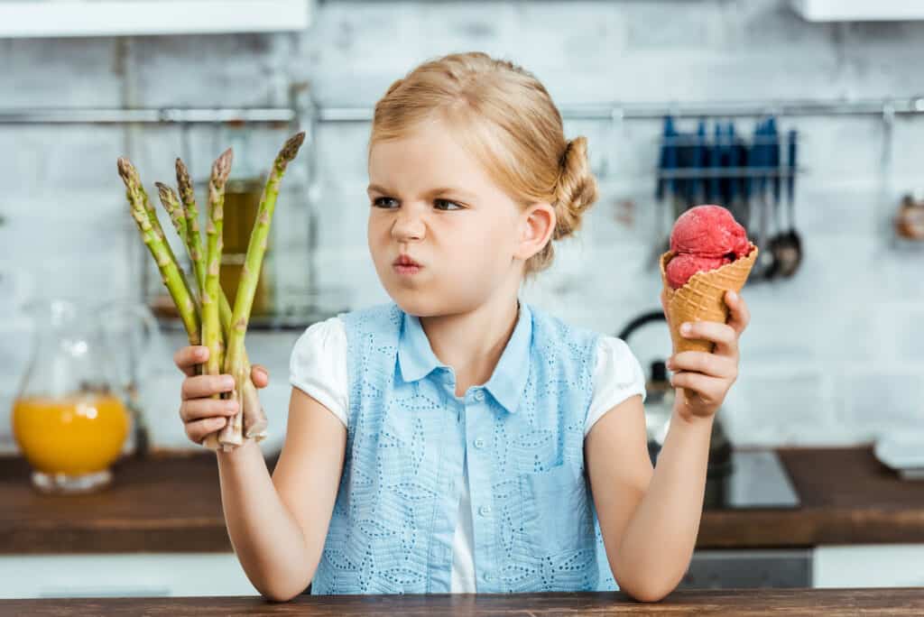 little-girl-choosing-between-asparagus-and-ice-cream