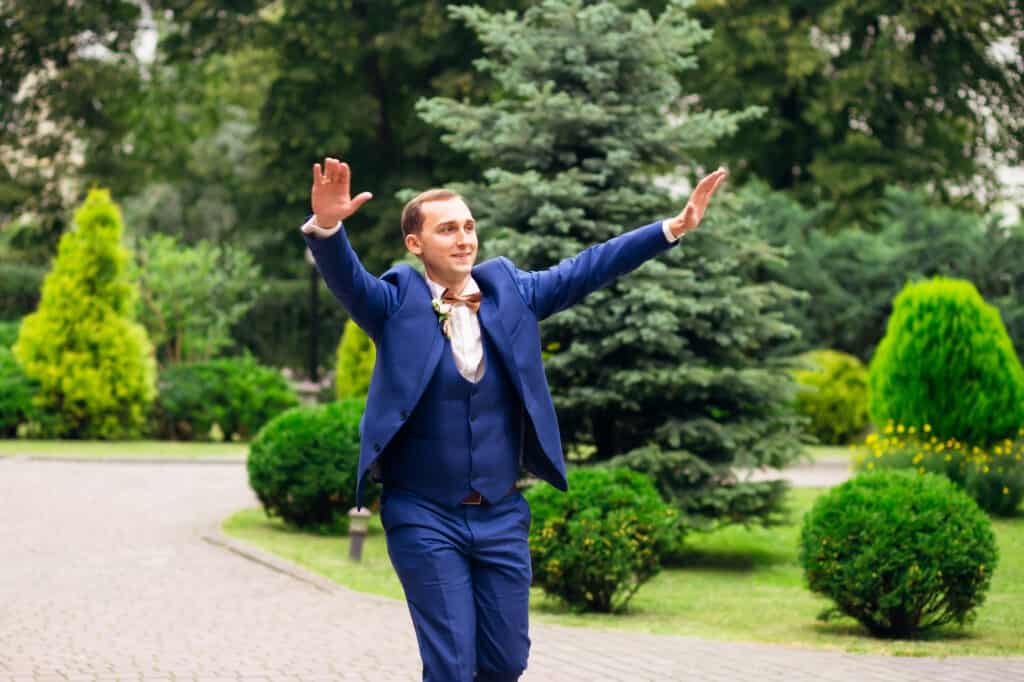 man-in-suit-holding-hands-up