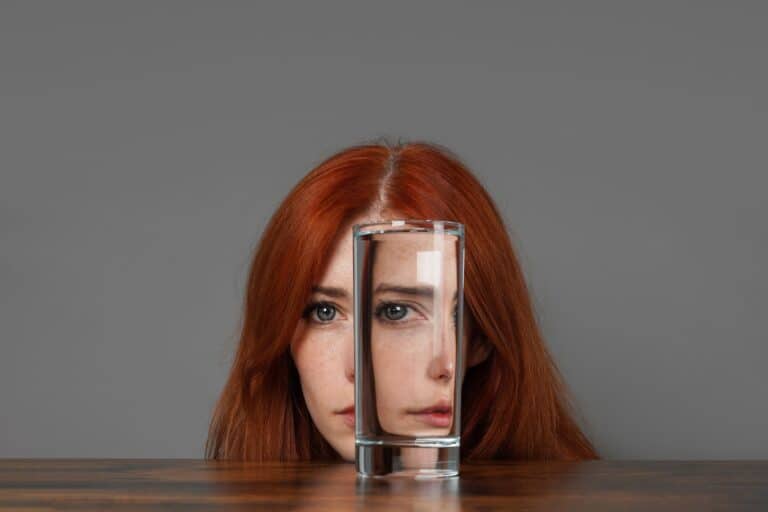 distorted-face-of-woman-looking-through-glass-of-water