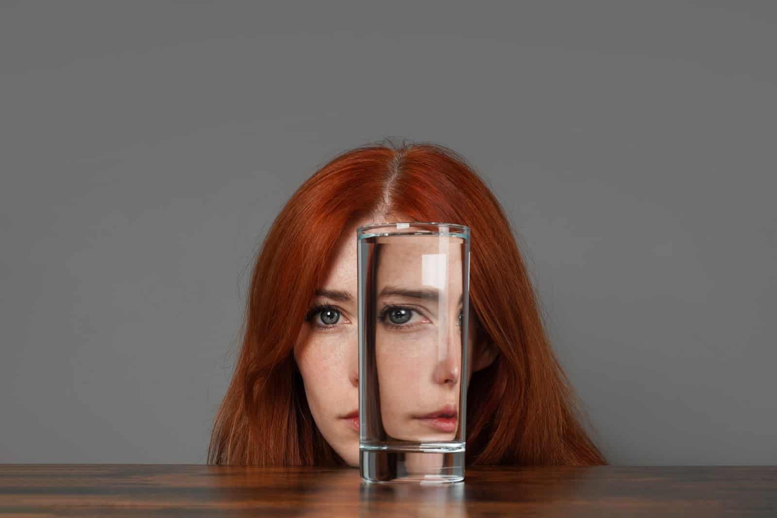 distorted-face-of-woman-looking-through-glass-of-water