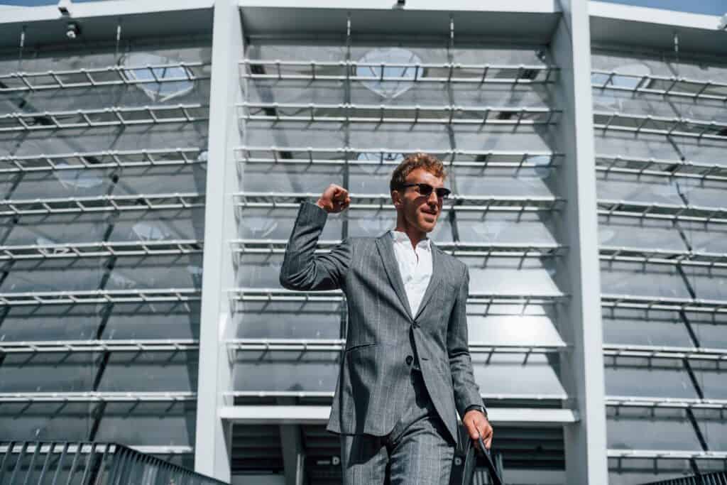 jumping-and-celebrating-success-young-businessman-in-grey-formal-wear-is-outdoors-in-the-city