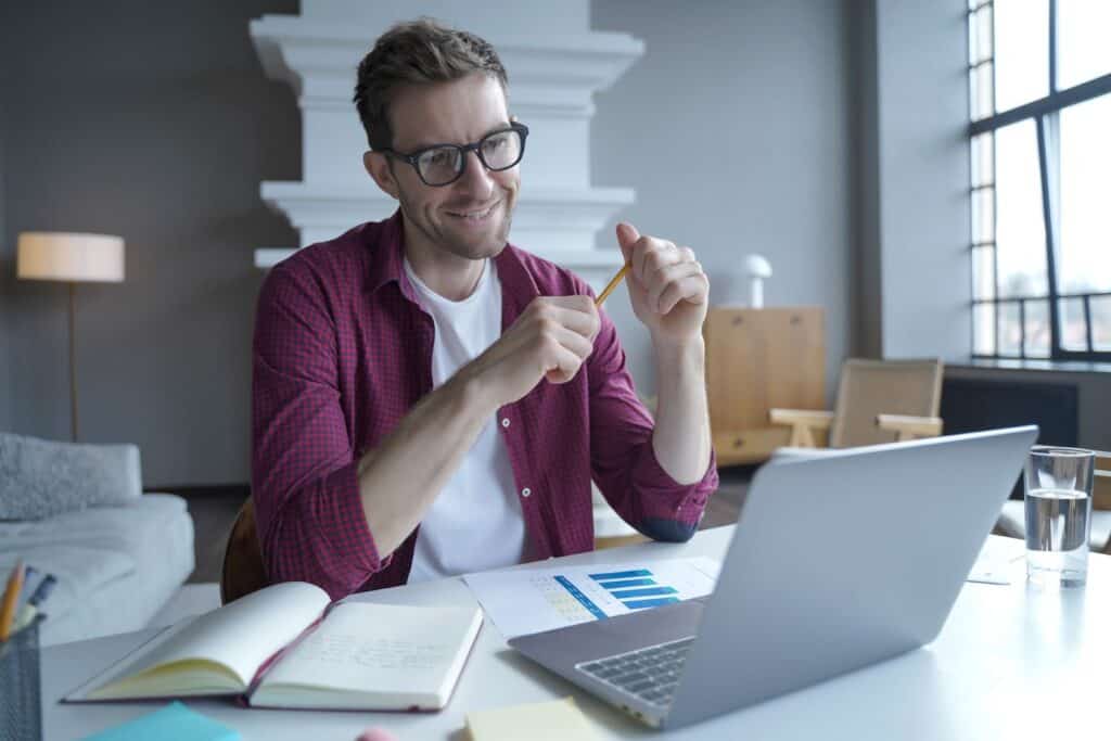 young-male-entrepreneur-in-glasses-having-pleasant-online-conversation-with-colleagues