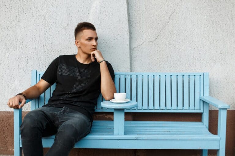 handsome-lonely-man-sits-alone-on-a-bench-and-drink-coffee