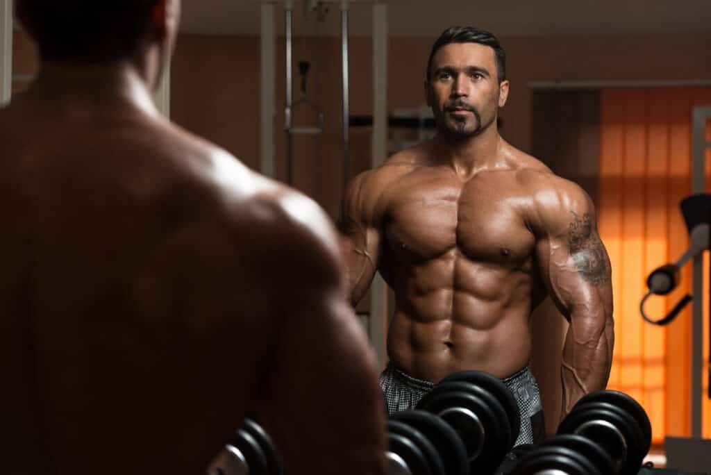 bodybuilder-exercising-biceps-looking-at-own-reflection