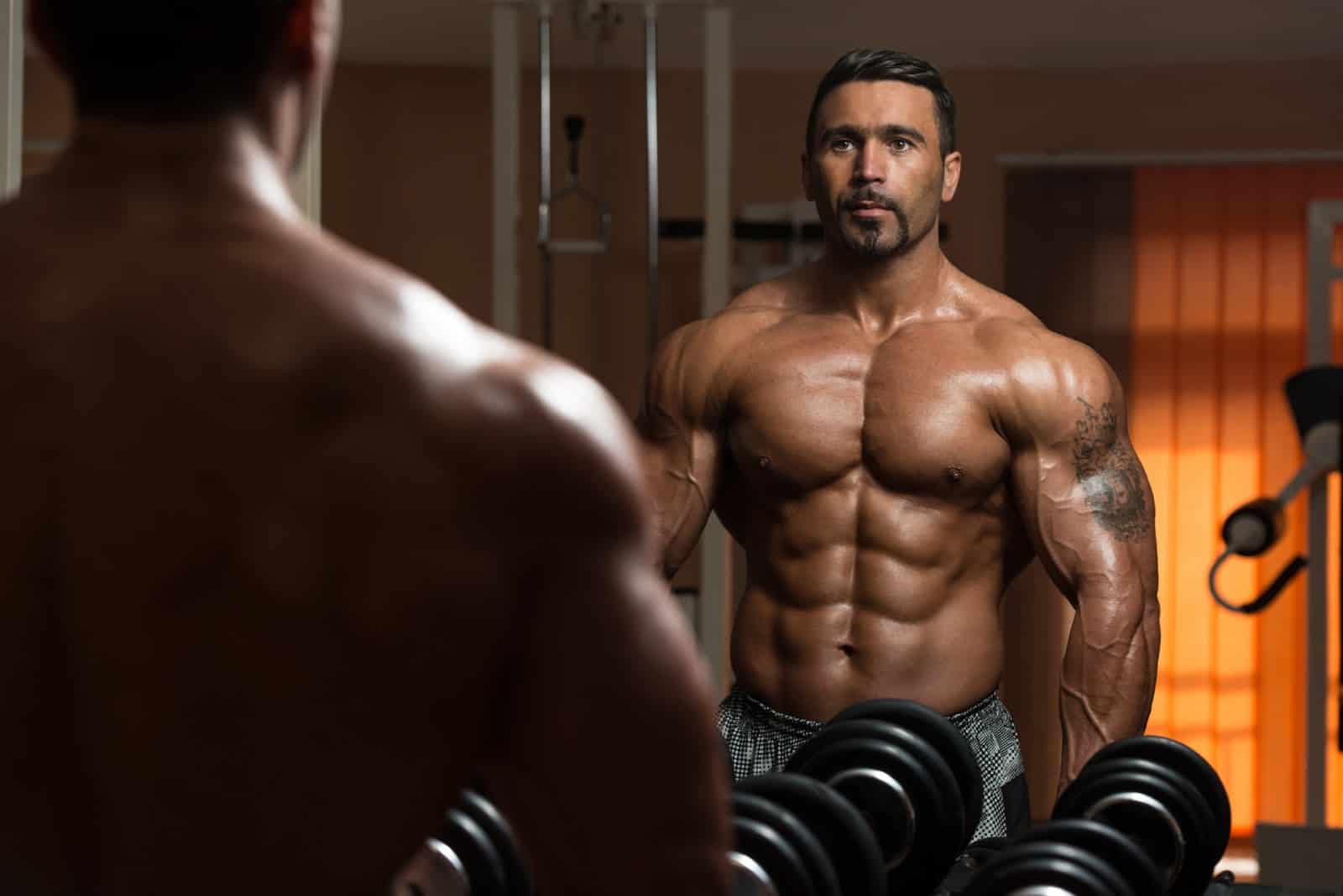 bodybuilder-exercising-biceps-looking-at-own-reflection