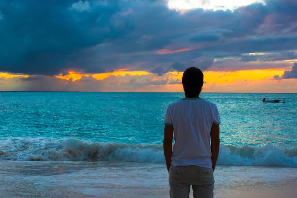 young-man-enjoying-sunset-during-beach-vacation