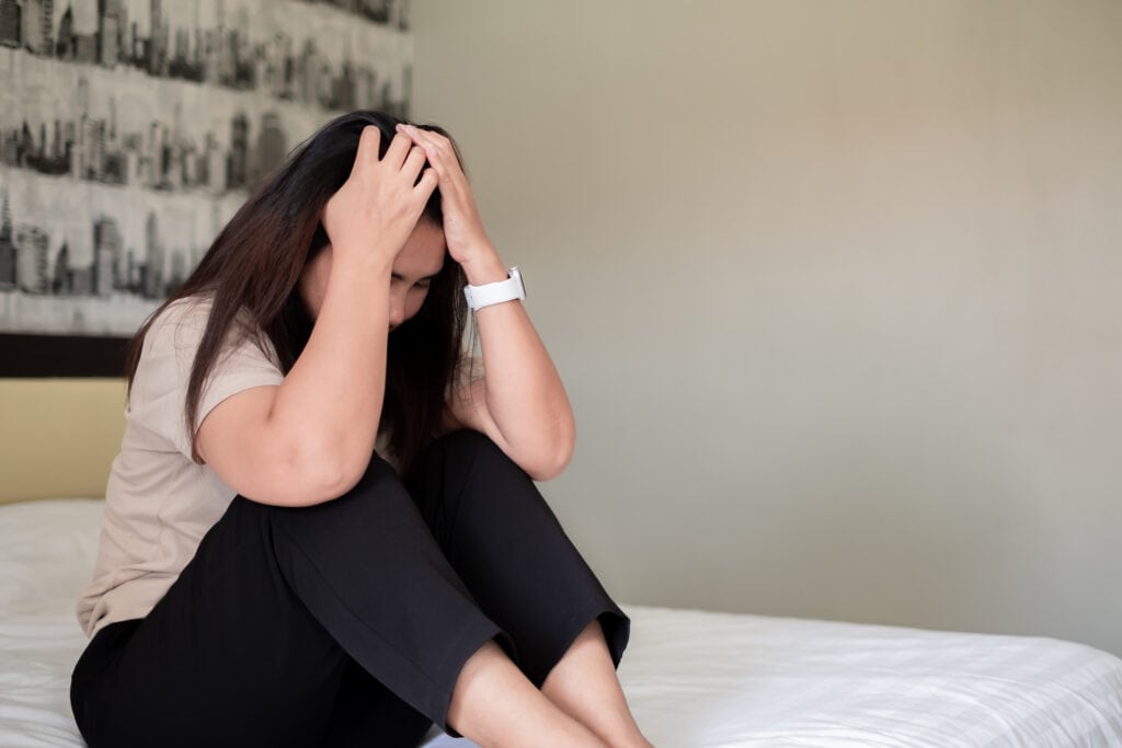 sad depressed asia woman suffering on the white bed