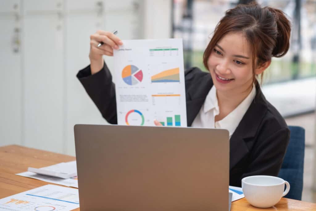 marketing financial accounting planning business women analyze company results and profits with graph statistics use a laptop computer and a calculator to calculate the company s balance