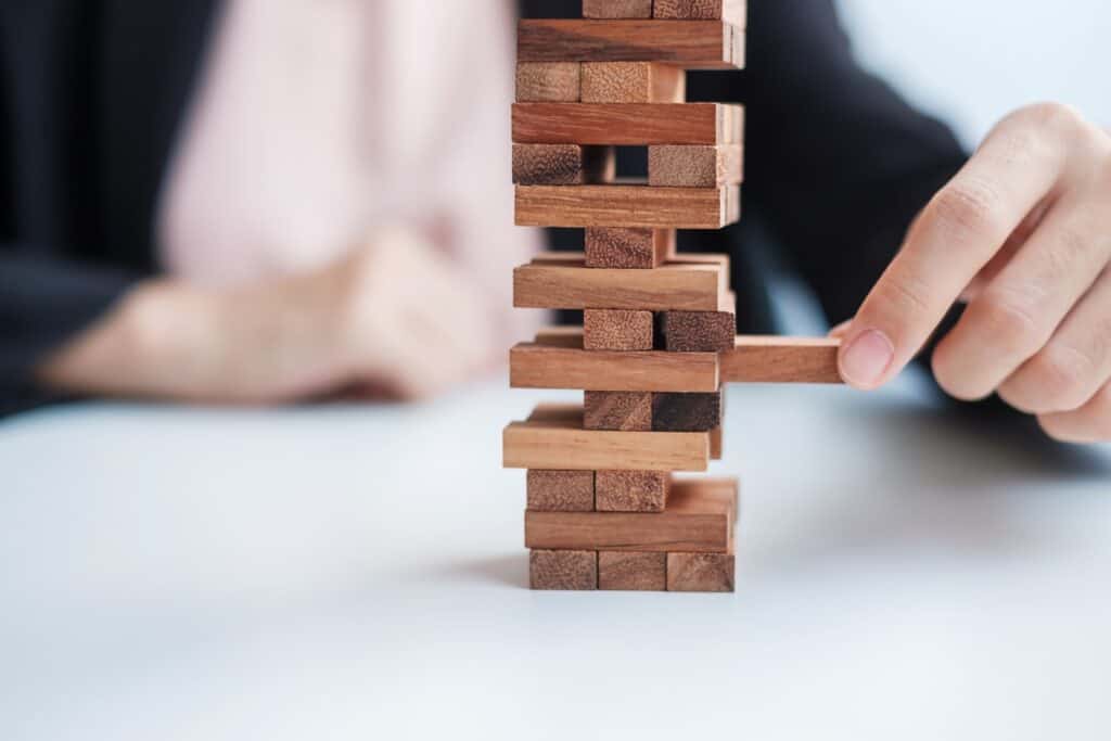 businesswoman-hand-placing-or-pulling-wooden-block-on-the-tower-business-planning-risk-management-solution-and-strategy-concepts