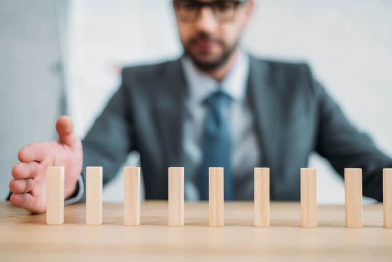 business-man-assembling-wooden-blocks-with-resilience-and-determination