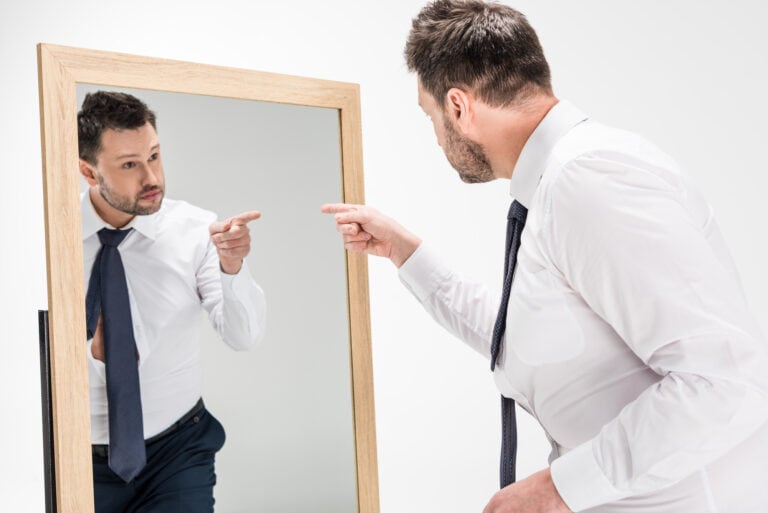 business-man-pointing-to-reflection-in-mirror