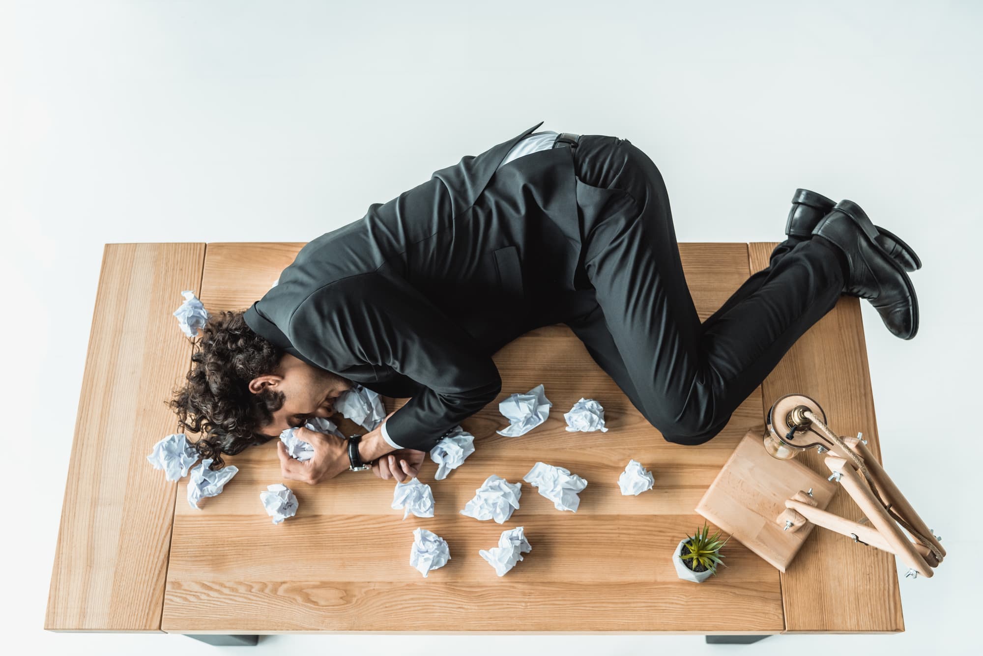 business-man-sleeping-on-table-with-crumpled-paper