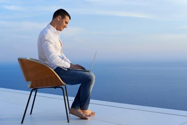 man-working-on-laptop-on-balcony